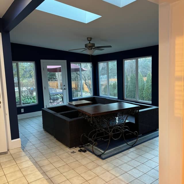 Games room with a dark painted ceiling, skylight and a wall of windows overlooking the garden